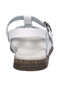 White sandal with adjustable strap, smooth material, flat sole, and gray accents. Features stitching along the edge and a metallic buckle.