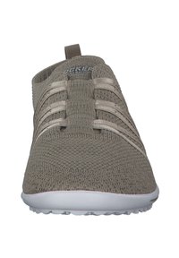 Beige slip-on shoe with a textured knit upper. Features elastic laces and a white rubber sole. Rounded toe design and a rear pull tab.