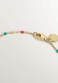 Cadena de oro con cuentas coloridas en turquesa, verde y rosa. Presenta un cierre de langosta y un charm redondo y texturizado.
