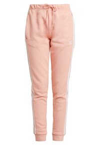 Rosa joggingsbyxor med en åtsittande design, som har vita sidostripes, dragsko i midjan och mjukt, texturerat material.