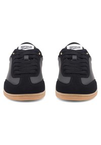 Mustad mustad, mis on valmistatud nahast ja sametist segust, sidumisdisainiga, kummist tallaga ja väikese logoga keele peal.