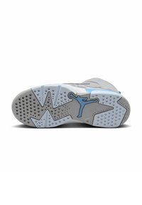 Šedá podrážka tenisky s modrými akcenty, texturovaná guma, kruhové a hvězdicové vzory, se znakem Jumpman v modré barvě.