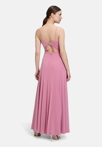 Różowa sukienka bez rękawów z wycięciem na plecach, zwiewny dół i delikatne ramiączka; wykonana z miękkiego, teksturowanego materiału.