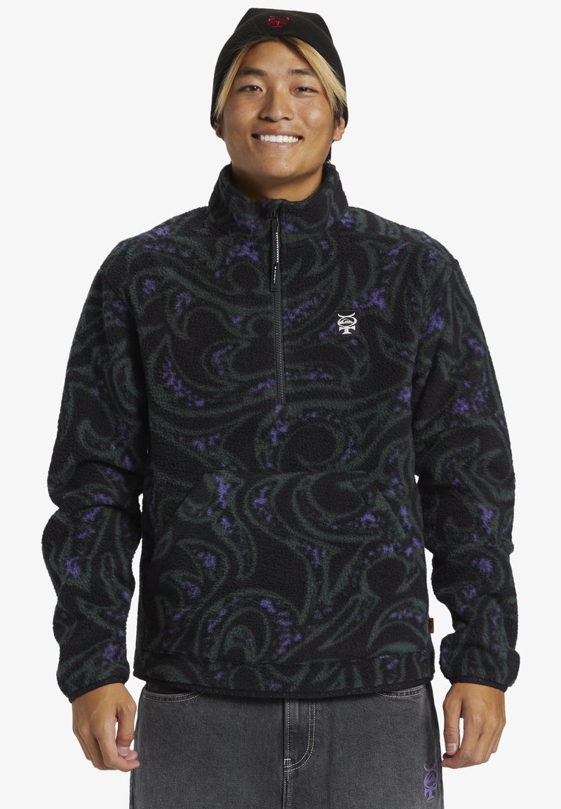 Schwarzer Fleece-Pullover mit wirbelnden grünen und lila Mustern, halbseitigem Reißverschluss und gerippten Bündchen. Verfügt über ein kleines Logo auf der Brust.