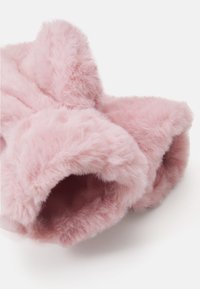 Bløde lyserøde faux fur slippers med en rund åbning, der har en blød tekstur og rullekanter for komfort.