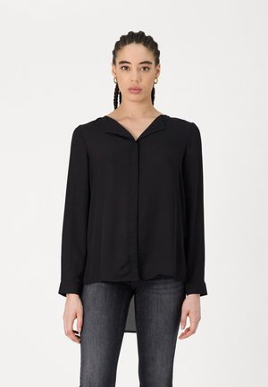 Blusa negra de manga larga con cuello en V, tejido suave y corte recto. Presenta un cierre de botones en la parte delantera y aberturas laterales.