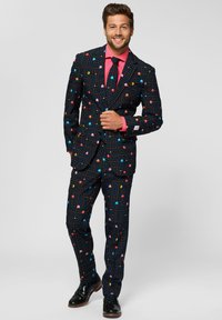 Black suit with a Pac-Man pattern, featuring colorful ghosts and dots, complemented by a pink shirt and tie, with shiny black shoes.