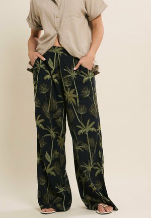 Pantalons larges en tissu léger avec un fond sombre et un motif de feuilles de palmier vertes. Comprend des poches latérales.