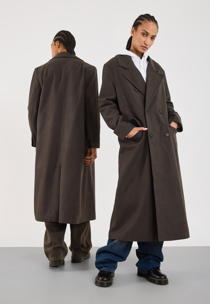 Long brown wool coat with a double-breasted design, wide lapels, side pockets, and tailored fit, shown from front and back.