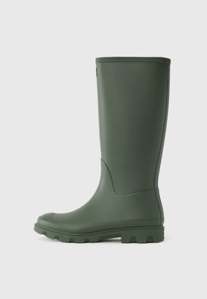 Botte de pluie en caoutchouc verte avec une texture lisse, bout rond et semelle robuste dotée de profondes rainures pour une adhérence optimale. La hauteur atteint le mi-mollet.