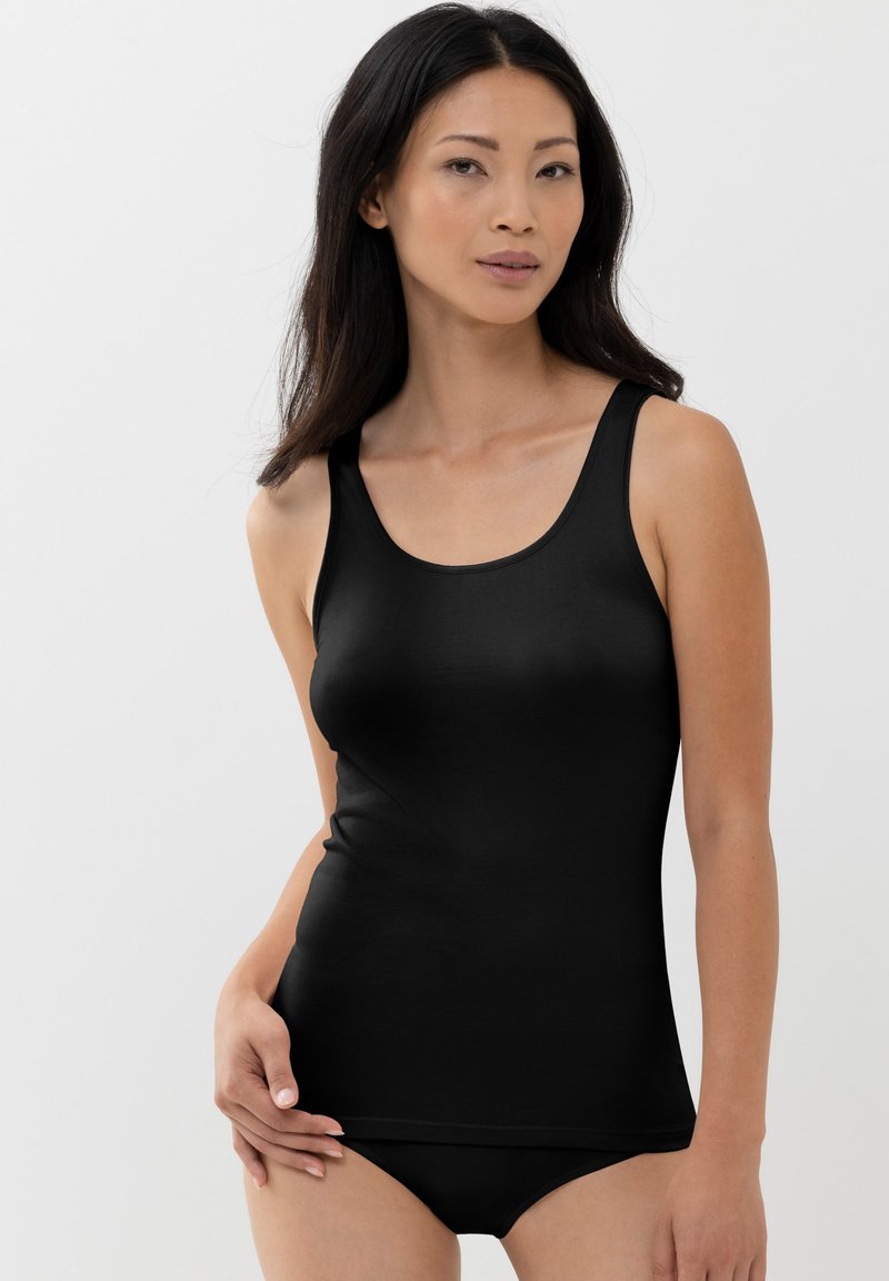 Black tank top made of smooth fabric, featuring wide straps and a fitted design. Paired with black briefs, emphasizing a seamless look.