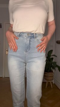 Svetlomodré rifle s vysokým pásom a vyblednutým efektom, s piatimi vreckami, predným zapínaním na gombík a priliehavým strihom, skombinované s bielym tričkom.