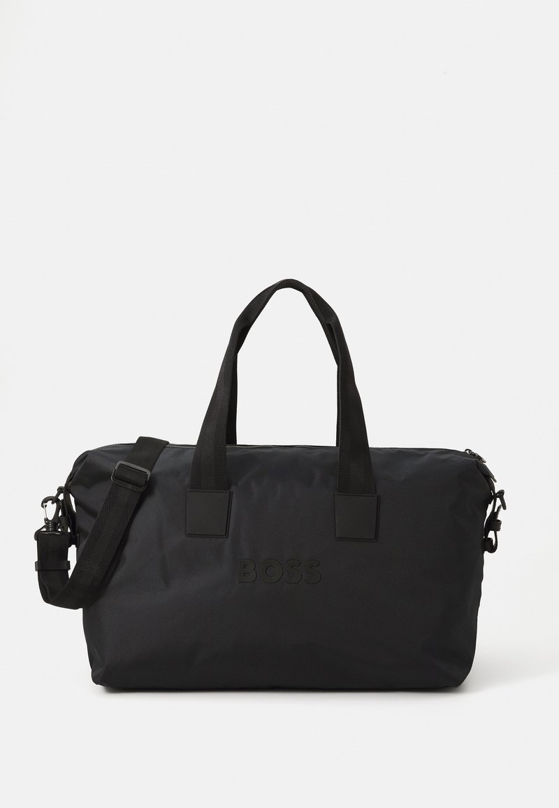 Geantă din nailon negru tip duffel, cu două mânere superioare și o curea de umăr detasabilă. Prezintă un logo embosat și o textură netedă, cu închidere cu fermoar.