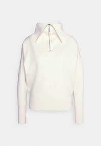 Crèmesweater met een hoge kraag en een rits aan de achterkant. Heeft een geribde zoom en manchetten, met een ontspannen pasvorm en een zachte textuur.