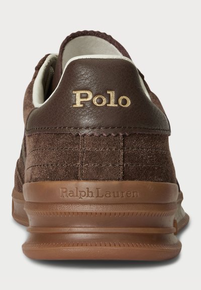 Brūni ādas un samta sporta apavi ar baltām akcentiem. Zelta "Polo" logo uz papēža un "Ralph Lauren" iegravēts uz zoles. Grosgrain detalizācija.