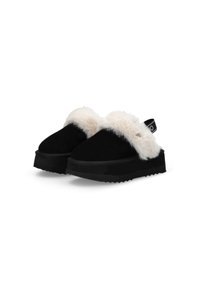Scarpe slip-on nere con un morbido bordo in pelliccia bianca, realizzate in suede, con suole nere spesse dotate di un motivo testurizzato e una fascia posteriore per supporto.
