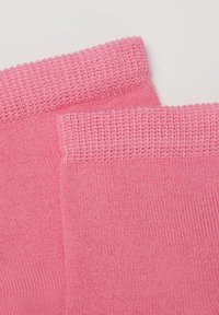 Lyserøde strikkede sokker med ribbet kant og glat overflade, lavet af strækbart stof for en komfortabel pasform.