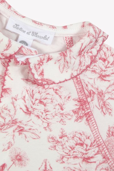 Stoff mit floralen Mustern in Rosa und Weiß. Weiche Textur, gewellter Ausschnitt und dekorative Stickerei entlang der Kanten.