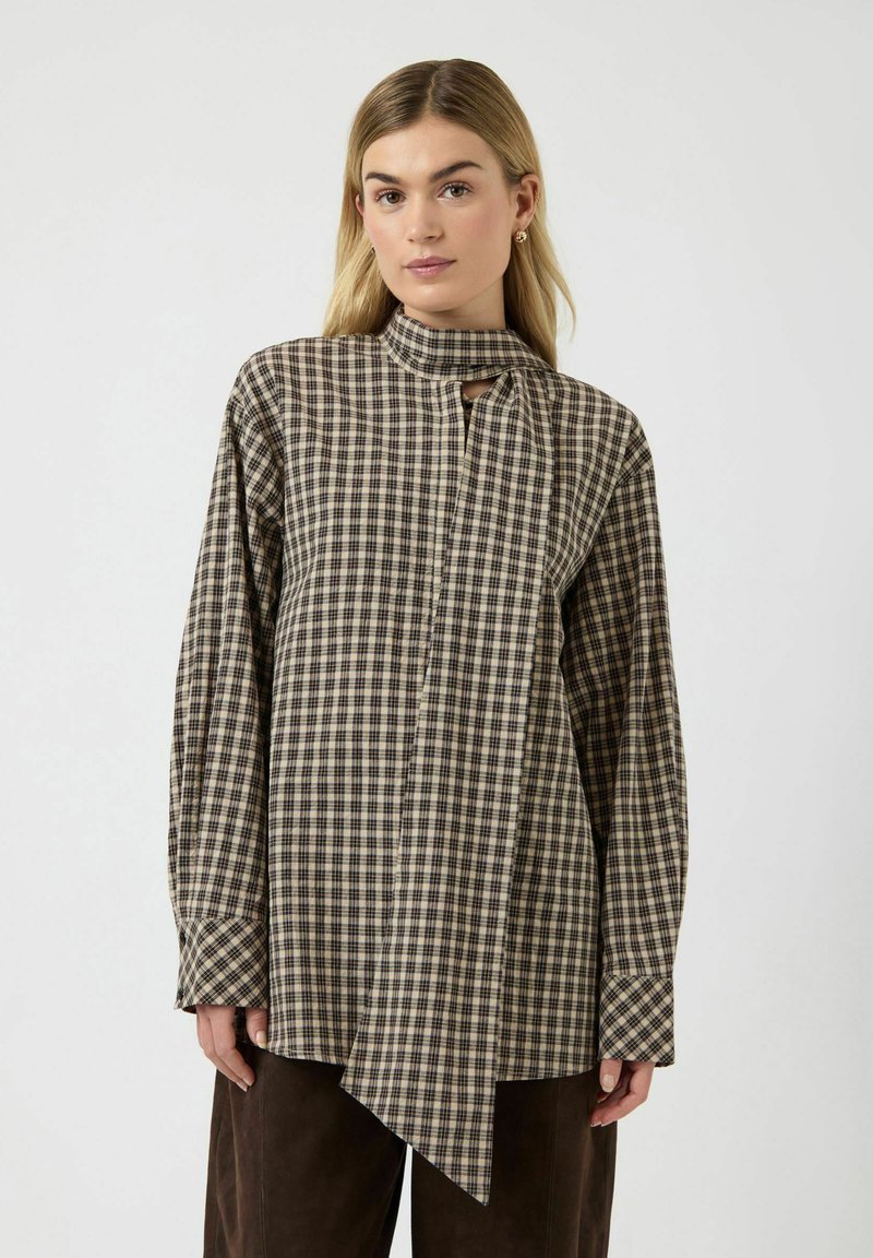 Brun og beige ternet skjorte med lange ærmer, høj krave, knapper foran og asymmetrisk kant. Fremstillet af et struktureret stof.