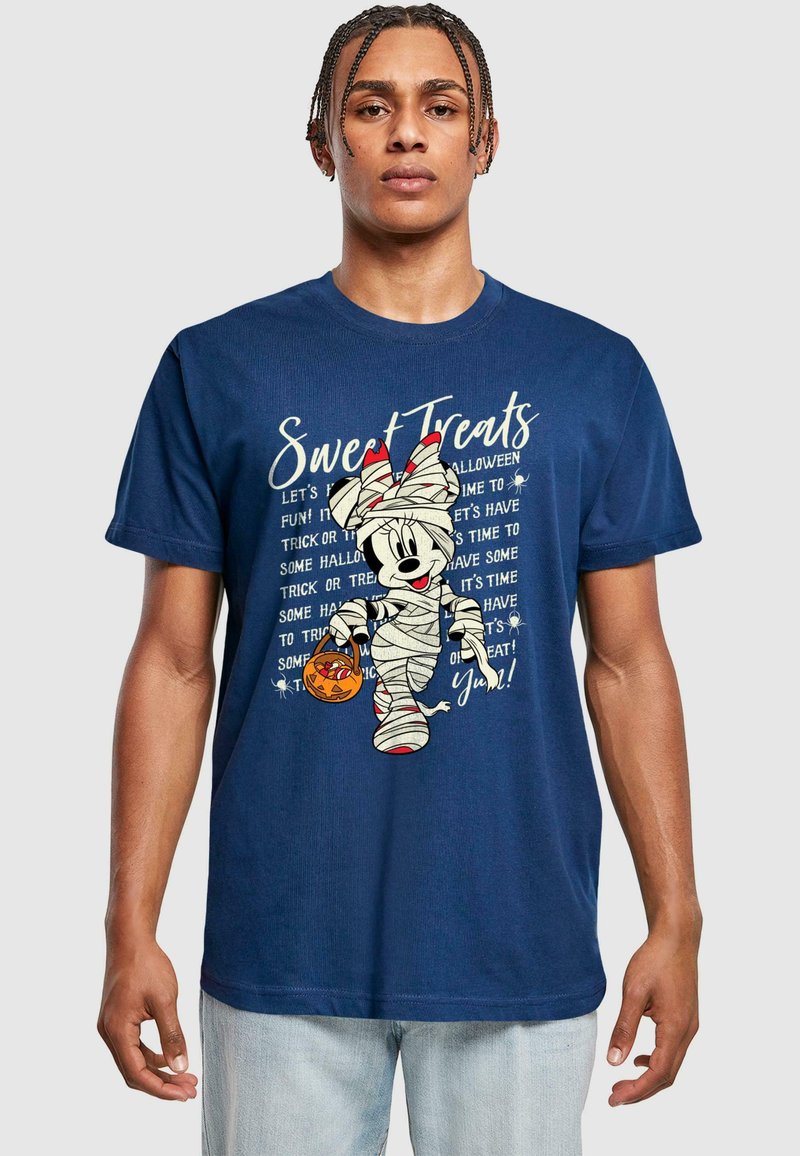 Marineblå T-shirt med et grafisk motiv af en indpakket karakter, der holder en græskar kurv, med hvid tekst som siger "Søde Godter" og halloween-tema detaljer.