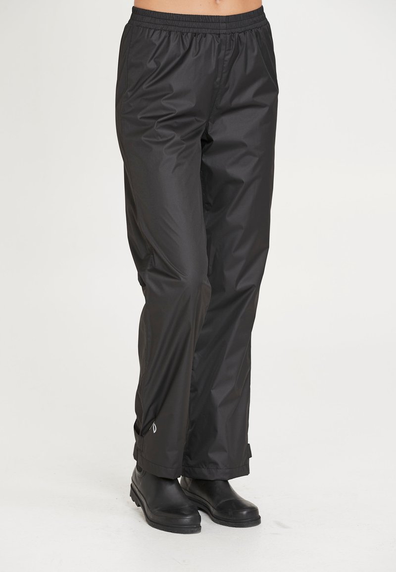 Sorte vandtette bukser med elastisk talje, lige ben-design og et reflekslogo-detalje nær sømmen. Glat, letvægtsstof.