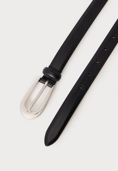Ceinture en cuir noir avec une boucle en métal argenté brillant et plusieurs trous de réglage sur un fond clair.