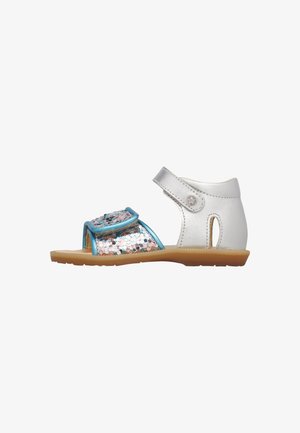 Sandalo per bambino piccolo bianco e blu con cinturini argentati glitterati, supporto alla caviglia e suola in gomma color cuoio, visto di lato su sfondo bianco.