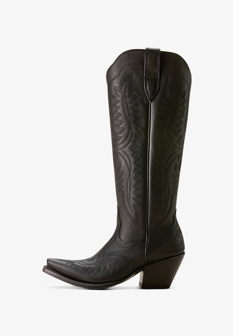 Botas de cowboy de cuero negro con punta puntiaguda, detalles bordados y un caña alta y curvada. Presenta un tacón cuadrado para mayor estabilidad.