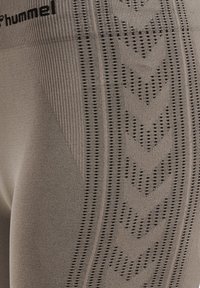 Grå träningsleggings med en texturerad design med vertikala ränder och chevronmönster, tillverkade av ett stretchigt, andningsbart material.