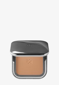Kompakt makeup-puder med präglad logotyp, förpackat i ett stilrent metalliskt silverfodral med delvis stängd lock.