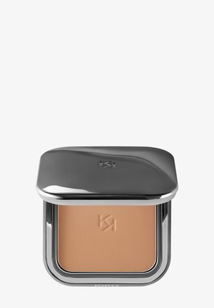 Kompakt makeup-puder med präglad logotyp, förpackat i ett stilrent metalliskt silverfodral med delvis stängd lock.
