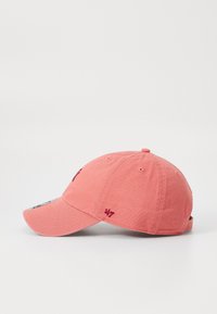 Gorra de algodón rosa con visera curva, logo bordado en la parte frontal y una pequeña etiqueta de la marca en el lado. Correa ajustable en la parte trasera.