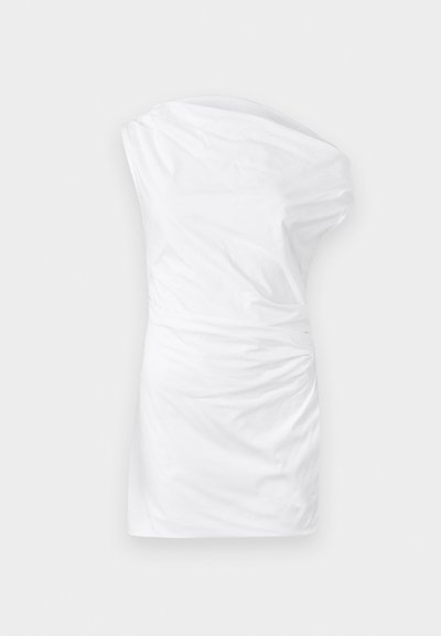 Egy vállra szabott, sima anyagból készült fehér ruha, oldalt csavart textúrával és testhezálló szabással.