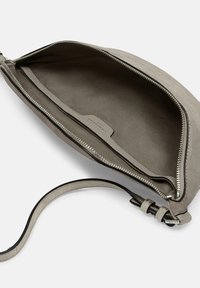 Borsa in suede grigio con texture liscia, chiusura con zip e tasca interna. La tracolla è regolabile e presenta distintivi accenti in metallo.