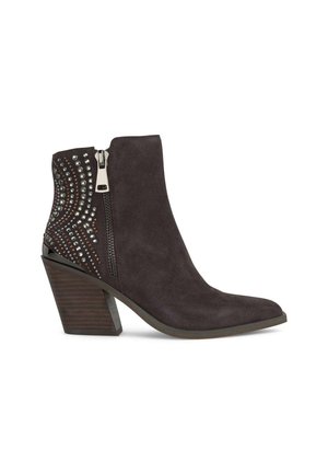 Bota de tobillo de ante gris oscuro con punta afilada, cremallera metálica lateral y acentos decorativos de tachuelas en la parte trasera. Tacón de madera grueso.