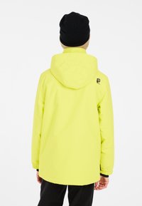 Veste à capuchon jaune vif, fabriquée en matériau lisse et imperméable. Elle comprend des poignets élastiques et un logo sur l'épaule.