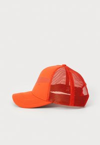 Casquette orange avec un devant solide et un dos en mesh, dotée d'un bord incurvé et d'un bouton sur le dessus. Le design comprend une bande audacieuse à l'avant.
