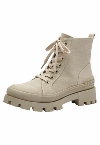 Bottines en toile beige avec une semelle en caoutchouc épaisse, à lacets à l'avant avec des œillets dorés, et une finition texturée. Comprend une languette de talon renforcée.