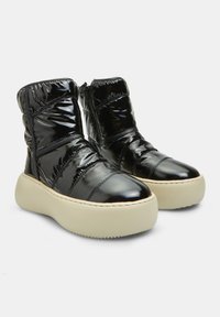 Botas de tobillo acolchadas negras con acabado brillante, que cuentan con cremalleras laterales, paneles texturizados y suelas gruesas de plataforma beige.