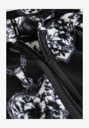 Mustvalge fliispullover peente mustritega. Omaduseks kontrastne must tõmblukk ja pehme, tekstuuriga kangas.