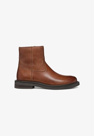 Braune Leder-Ankle-Boots mit glatter Oberfläche, elastischen Seitenpaneelen und einem niedrigen Blockabsatz. Mit kontrastierendem Stich entlang der Nähte.