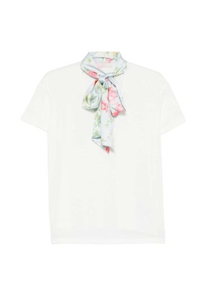 Witte top met korte mouwen en een lichtblauwe bloemen sjaal gestrikt in een losse strik bij de halslijn.