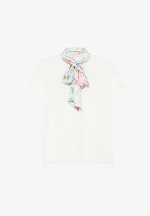 Top blanco de manga corta con una bufanda floral azul pálido atada en un lazo suelto en el escote.