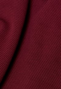 Bordeaux gekreukt stof met een fijne ribstructuur, die een zachte, gladde oppervlakte en een rijke, diepe tint toont. Ideaal voor verschillende textieltoepassingen.