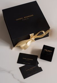 Black gift box with gold lettering, satin ribbon, and a velvet ring box. Two cards for "Diamond Collection" and "Guarantee Certificates."