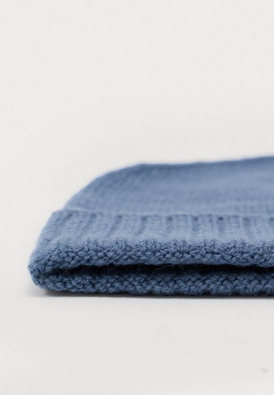 Bonnet en tricot bleu avec un motif texturé, doté d'un revers et d'un matériau doux. La couleur est uniforme, sans embellissements visibles.