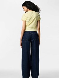 Żółta bluzka z krótkim rękawem w połączeniu z wysokim stanem i szerokimi nogawkami ciemnoniebieskich dżinsów, z tylnymi kieszeniami i czystym, minimalistycznym designem.