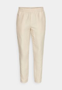 Beige linnen broek met een taps toelopende fit en elastische tailleband, met een soepele textuur en een eenvoudig ontwerp, zonder zakken of versieringen.