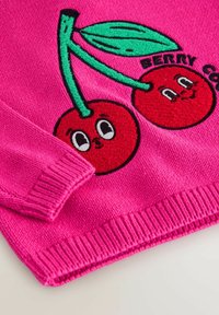 Maglione a maglia di un brillante colore rosa con una coppia di ciliegie sorridenti ricamate e una foglia verde, con maniche parziali e orlo a costine visibili.