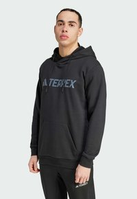 Črna kapuca z sprednjim kenguru žepom, nastavljivo vrvico in modrim logotipom "TERREX" čez prsa. Mehka tekstura.